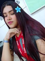 Person with Dark Red Hair and Blue Flower Accessory