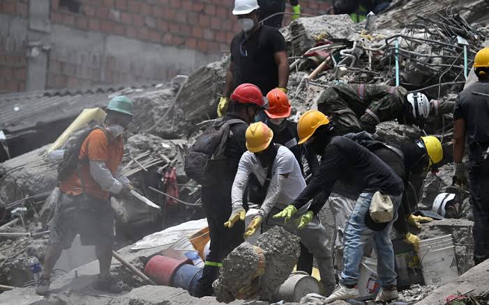 Search and rescue teams navigate through the rubble of destroyed buildings in Colombia following a massive earthquake.