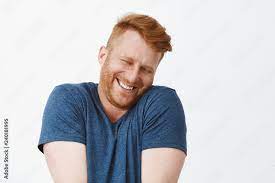 Fotografia Do Stock Oh Stop It You Portrait Of Cute Pleased And Satisfied Happy And Funny Redhead Man In Blue T Shirt Shrugging And Leaning Face On Shoulder While Smiling Broadly Blushing From