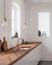 A Chevron Clad Wooden Butcher Block Countertop Adds A Textural Touuch To The Sleek White Cabi Warm Home Decor Interior Design Kitchen Kitchen Countertop Trends