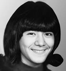 Please collect this photo of my sister. She has brown eyes and dark hair.