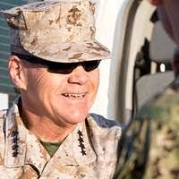 Spc. Jonathan Garza carries a log out of the woods