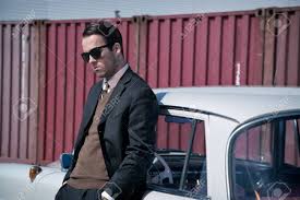 Achat vetement annee 60 au meilleur prix. Retro Homme D Affaires De La Mode Des Annees 60 Portant Le Costume Gris Et Lunettes Noires Debout Contre Voiture Classique Banque D Images Et Photos Libres De Droits Image 31267894