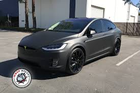 The matte black wrap is offset by a red tesla logo in the front and rear. 3m Matte Deep Black Wrap Bullys