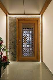 A wooden double door main door design with antique handle and ganesha mural at the entrance of an indian home. Door Designs For Your Home S Main Entrance And Rooms