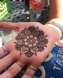 As authority tattoo notes, henna can last anywhere from a week to a few months, depending on its location, which assists with longevity provided the area boasts thicker skin (such as the soles of your feet, palms of your hands, or your stomach). Henna Hand Tattoo Designs Perfectly Symmetrical Flower Mandala Painted With Brown Henna On The Palm O Henna Tattoo Hand Cool Henna Designs Henna Hand Tattoo