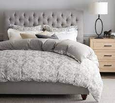 A bedroom with a rough brick wall could easily adopt an edgy, industrial or goth style, but if you prefer a softer look, just contrast the brick with a gentle palette of gray, eggshell white, and black. Chesterfield Tufted Upholstered Bed Pottery Barn