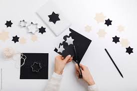Cut your shape twice, add a score line, glue above it. Female Hands Cut Star Shaped Cards To Make Gift Package By Michela Ravasio