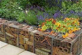 Here Is Another Image Of A Unique Gabion Wall The Wire Cages Are Filled With Recycled Terracotta Pots An Sloped Garden Garden Retaining Wall Backyard Fences