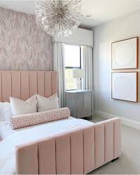 This contemporary white master bedroom features a bold black and white floral wallpaper accent wall, gray and white upholstered and tufted furnishings, and pops of pink. 19 Feminine Bedrooms With Style