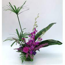 A High Style Arrangement Featuring Dendrobium Orchids Heather Statice And Carnations All In Shades Of Flower Arrangements Carnation Flower Dendrobium Orchids