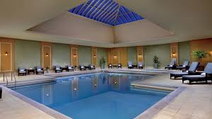 An Indoor Pool Underneath A Large Skylight And Surrounded By Lounge Chairs Luxury Hotel Luxury Pools Ritz Carlton