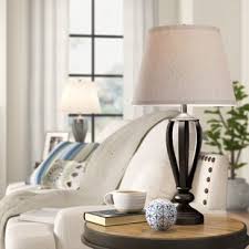By strategically placing a table lamp or a floor lamp in a corner, the living room feels larger because it adds accent light to a space that is often not reached by ambient light. Table Lamps Wayfair