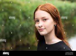 Ragazza di dodici anni dai capelli rossi con lenticelle in posa con sfondo  bokeh naturale, Bruxelles, Belgio Foto stock