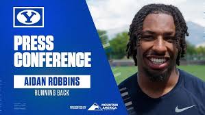 Aidan Robbins talks with the media after a practice