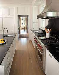 The texture and veining of this stone are larger and more scattered compared to engineered stones. White Shaker Kitchen Cabinets With Black Soapstone Countertops Transitional Kitchen