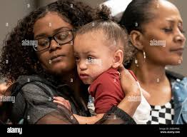 Daunte Wright Jr, center, son of the deceased Daunte Wright, cries in the  eyes of his mother Chyna Whitaker, left, alongside his grandmother Erica  Whitaker during a news conference, Friday, April 16,