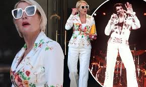 Heather Mills, 54, channels Elvis in a white flared trouser suit