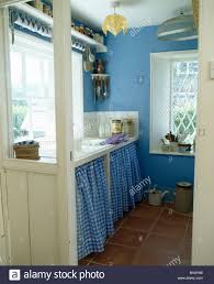 blue checked curtains on cupboard below