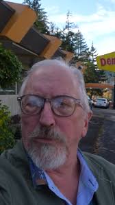 Smith Family Bookstore employee Michelle Loew is dwarfed by a stack of  books in the entry way of the downtown bookstore as she and other employees  work to move books from the