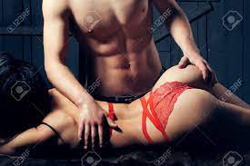 Mujer Joven Desnuda Sensual Con Bellos Cuerpo Recto De Encaje Rojo Ropa  Interior Erótica Que Miente Cerca De Hombre Musculoso Posando Tocar Las  Nalgas De Interior En El Fondo De Madera, Imagen