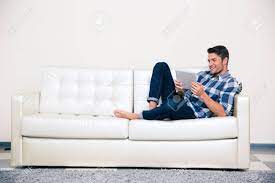 Das bild hängt über dem sofa. Portrait Eines Beilaufigen Mann Auf Dem Sofa Mit Tablet Computer Liegen Lizenzfreie Fotos Bilder Und Stock Fotografie Image 45842488