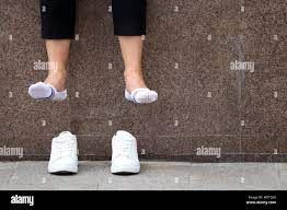 Woman dangling her shoes hi-res stock photography and images - Alamy