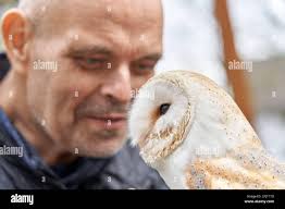 Koblenz, Germany. 29th Mar, 2023. Jose Lay, hospice resident, enjoys being  close to Merlin the white-faced owl from the "Falconers of Hearts"