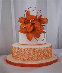 Stunning Colours And Designs Two Tier White Wedding Cake With Orange Detailing And Orange Flo Flower Cake Decorations Wedding Sheet Cakes Flower Cake Toppers