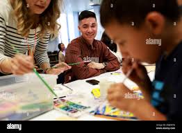 Volunteer Ren Norderhaug (center), 21, watches the interaction between  facilitator Caroline Wallace (left), 43, and Gabe Lima, 7, during drawing  class at the Hamilton Family Shelter, located at 260 Golden Gate, in