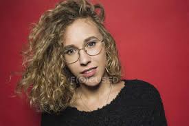 Men with glasses can often look very serious, sometimes even cold and uninterested. Portrait Of Woman With Curly Hair And Wearing Glasses Against Red Background Beautiful Woman Front View Stock Photo 232237778