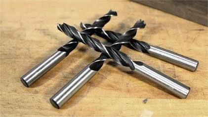 The sharp center spike of a brad point bit prevents the drill from wandering on smooth wood, AI generated