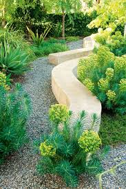 Drought Tolerant Garden Curved Stone Walls With Plantings Of Euphorbia Along The Gravel Path This Drought Tolerant Garden Drought Tolerant Landscape Garden