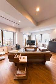 ウォールナットの背板が美しいソファは 大胆にリビングに対して斜めに設置 窓の外には東京タワーが見える リビング 配置 リビング 家具のアイデア