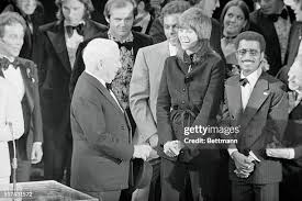 Comic Charlie Chaplin turns and shakes hands with singer Johnny... News  Photo