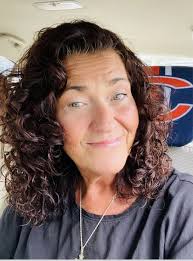 What hairstyle suits a 58-year-old woman with curly hair and a round face?