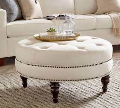 The table top is etched metal surrounded by a medium. Martin Upholstered Round Ottoman Round Ottoman Ottoman Decor Fabric Coffee Table