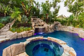 Backyard pools with slides and waterfalls. Tropical Backyard With Water Slide Caves For Exploring Distinguished Pools Inc Hgtv