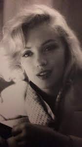 Marilyn. Camel coat sitting. Photo by Milton Greene, 1953.