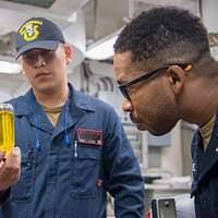 Gas Turbine Systems Technician (Mechanical) 3rd Class Victor Gatjens, from  Ft. Myers, Florida, pours JP-5 fuel into a bottle during a contaminated  fuel detector test