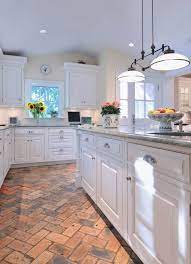 A red brick herringbone pantry floor boasts white drawers fitted with oil rubbed bronze hardware and positioned beneath stacked seeded glass cabinets. Basic White Kitchen With Brick Flooring Holds The Heat In The Winter And Is Cool In Summer Kitchen Design Modern White Kitchen Remodel Country Kitchen