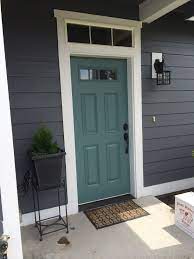 Sophisticated and timeless, dark gray makes an excellent front door color for more traditional house styles. Carribean Teal Door Front Door Colors Gray House Gray House Exterior Exterior Door Colors House Paint Exterior