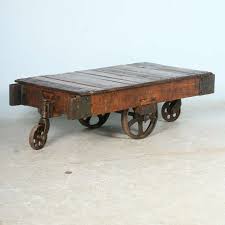 Sporting a weathered white wash, this table's base includes one open shelf for displaying coffee table books or fanning out issues of your favorite magazines, while hidden wheels make it easy to move the table for parties and events. Antique Vintage Luggage Cart Coffee Table Circa 1920 With Cast Iron Wheels At 1stdibs