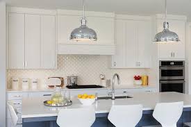 The tile flooring in this kitchen this kitchen features a tile backsplash sandwiched between white countertops and light wood. White Diamond Pattern Cooktop Tiles With White Wood Range Hood Transitional Kitchen