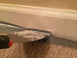 For painting over baseboards in rooms with hard flooring such as wood, tile or laminate, carefully run painter's tape along the floor where it meets the trim. How To Paint Baseboards Titan Painters Painting Baseboards Baseboards How To Clean Carpet