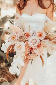 A colorful tropical beach wedding bouquet in yellow, coral and red, with much greenery. 74 Dreamy And Relaxed Bohemian Wedding Bouquets Weddingomania