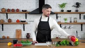 If you're looking to boost your small kitchen's functionality and fun without tearing it down to the studs, these useful design ideas can transform the space. Man Chef Cook In Home Kitchen Greets Tells Shows Ingredients For Cooking Salad By Viacheslavpetrusha