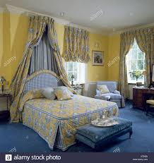 Blau gibt es in zig unterschiedlichen nuancen: Gelbe Blau Gemusterte Abdeckung Auf Bett Mit Passenden Vorhangen Auf Coronet In Traditionellen Gelben Schlafzimmer Mit Blauen Teppich Stockfotografie Alamy