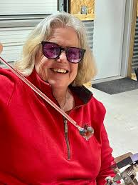 Young ladies create glass heart pendants in class