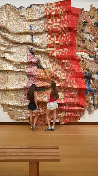 Back in the museum: El Anatsui ✨ Get immersed in this huge artwork, made  entirely out of countless bottle caps! Each one is flattened and connected  to others with copper wire. The wall sculpture folds ...